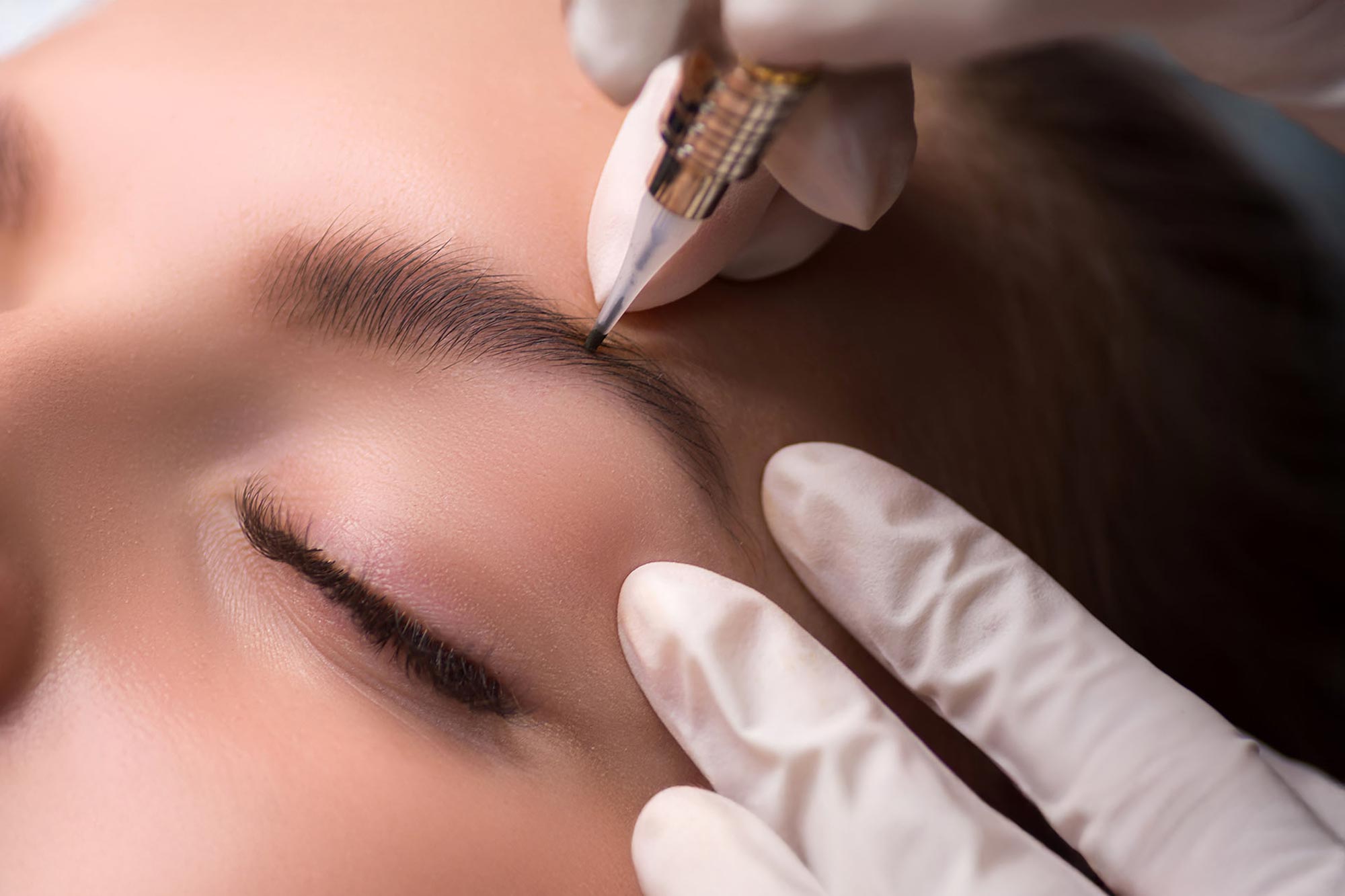 En kvinna får permanent makeup i sitt ansikte